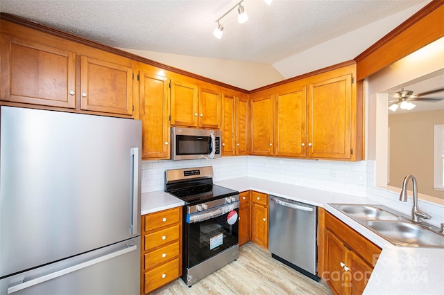 kitchen featuring decorative backsplash, appliances with stainless steel finishes, ceiling fan, sink, and lofted ceiling