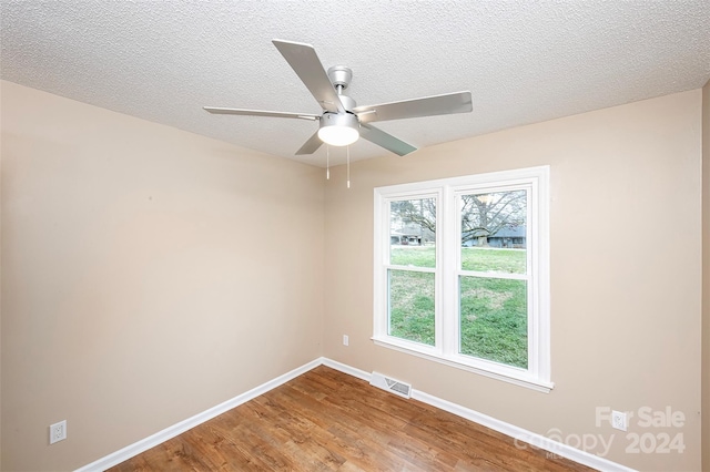 empty room featuring ceiling fan, a textured ceiling, and hardwood / wood-style flooring