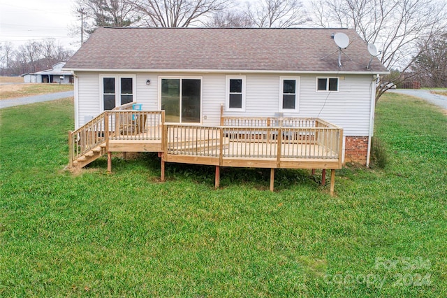 back of house featuring a lawn and a deck