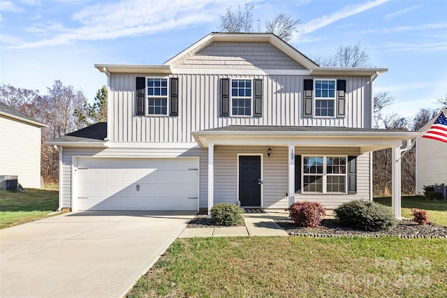 view of property with covered porch, a front yard, and a garage