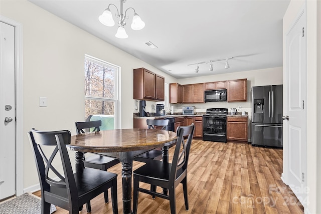 dining room featuring light hardwood / wood-style flooring and an inviting chandelier