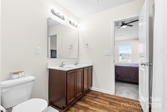 bathroom with ceiling fan, vanity, wood-type flooring, and toilet