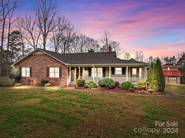 single story home featuring a lawn and a porch