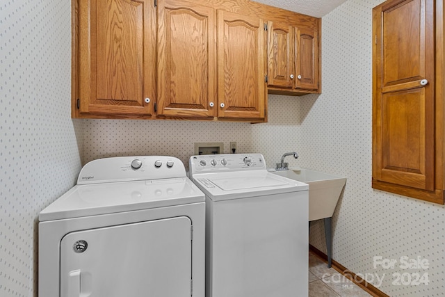 washroom with washer and clothes dryer, cabinets, and light tile patterned floors