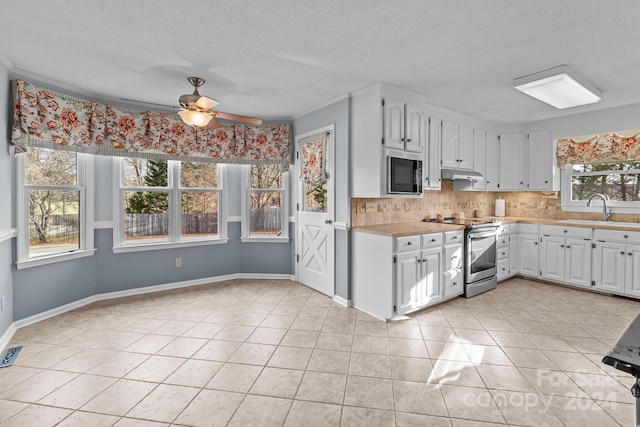 kitchen with electric stove, built in microwave, sink, and white cabinets