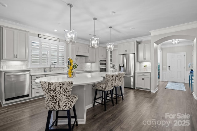 kitchen featuring hanging light fixtures, dark hardwood / wood-style flooring, stainless steel appliances, and a kitchen island