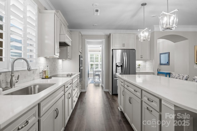 kitchen with pendant lighting, sink, white cabinets, and appliances with stainless steel finishes