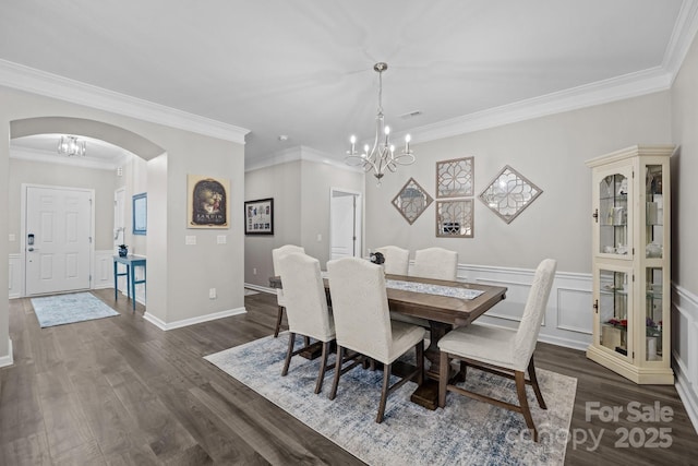 dining space featuring an inviting chandelier, dark hardwood / wood-style flooring, and crown molding