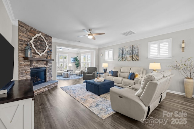 living room featuring dark wood-type flooring, crown molding, a fireplace, and ceiling fan