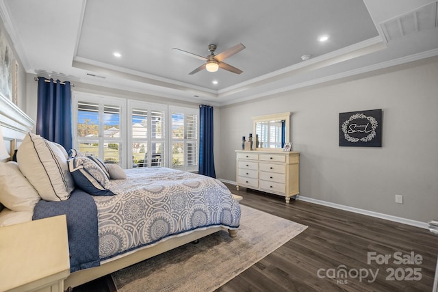 bedroom featuring dark wood-type flooring, ceiling fan, crown molding, and a tray ceiling