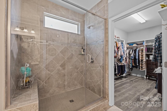 bathroom with a shower with shower door and wood-type flooring