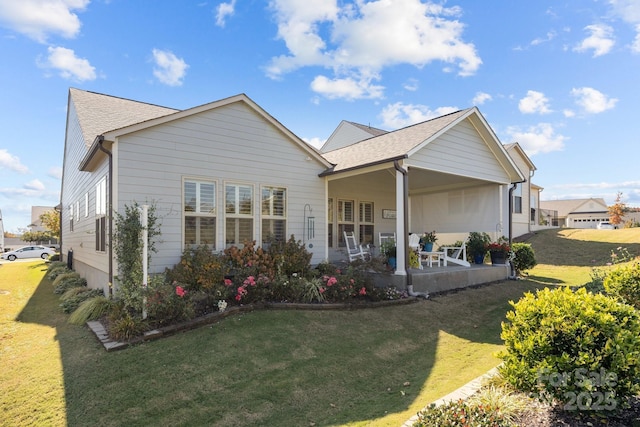 rear view of property featuring a lawn and a patio