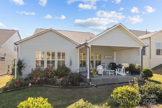 back of property featuring a patio and a yard