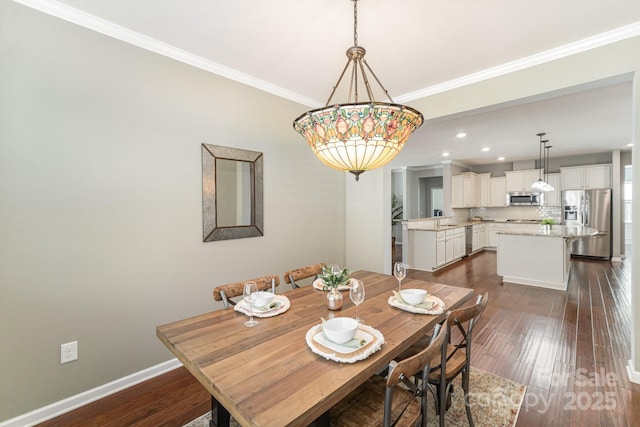 dining room featuring sink, crown molding, and dark hardwood / wood-style floors