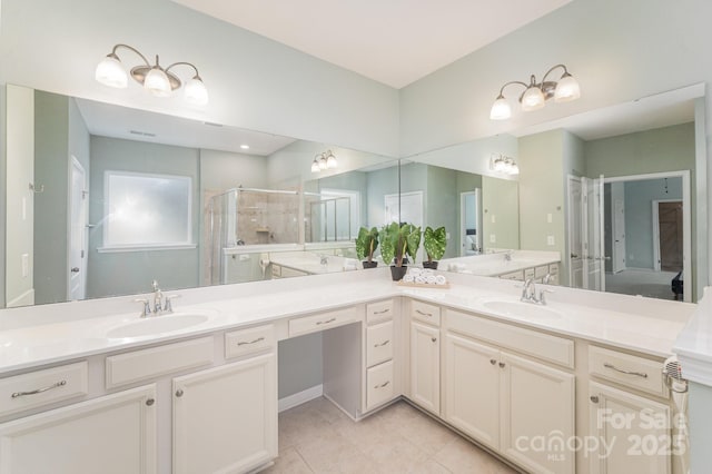 bathroom with a shower with door, tile patterned flooring, and vanity