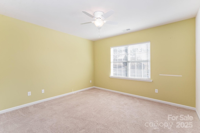 spare room with ceiling fan and light carpet