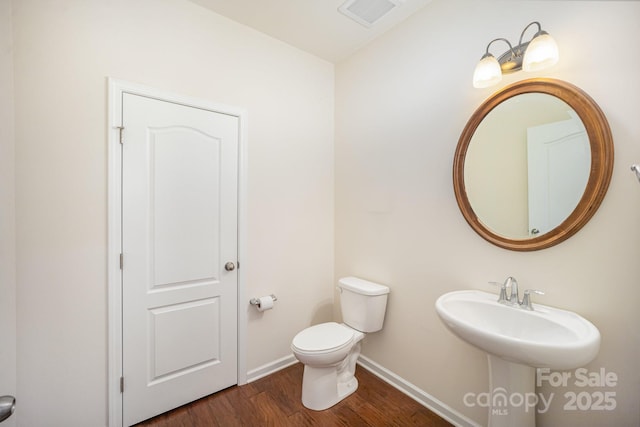 bathroom with wood-type flooring and toilet