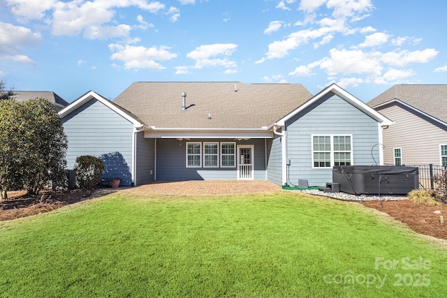 rear view of house featuring a hot tub, a yard, and a patio