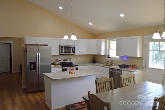 kitchen featuring stainless steel appliances, hanging light fixtures, and white cabinets