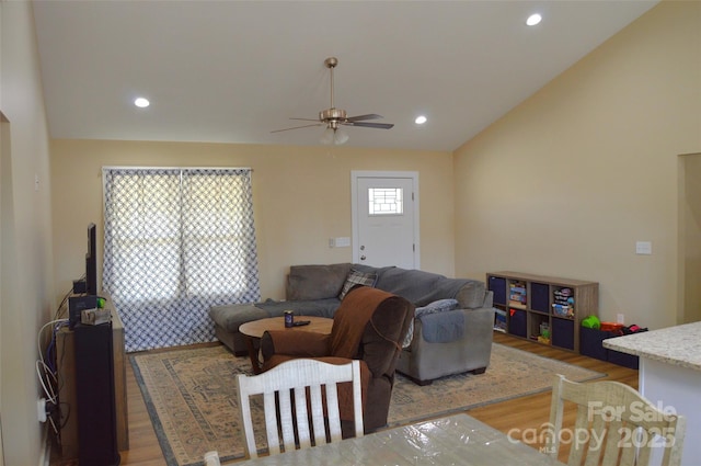 living room with vaulted ceiling, hardwood / wood-style floors, and ceiling fan