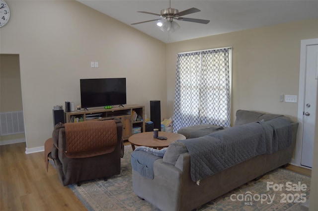 living room featuring hardwood / wood-style flooring, ceiling fan, and vaulted ceiling