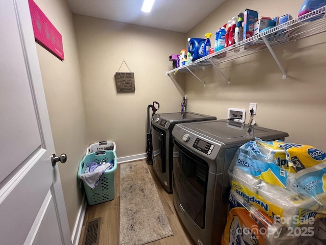 laundry room featuring light hardwood / wood-style flooring and washer and clothes dryer