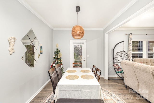 dining area with hardwood / wood-style flooring and ornamental molding