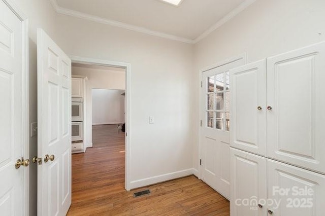 hall with hardwood / wood-style floors and crown molding