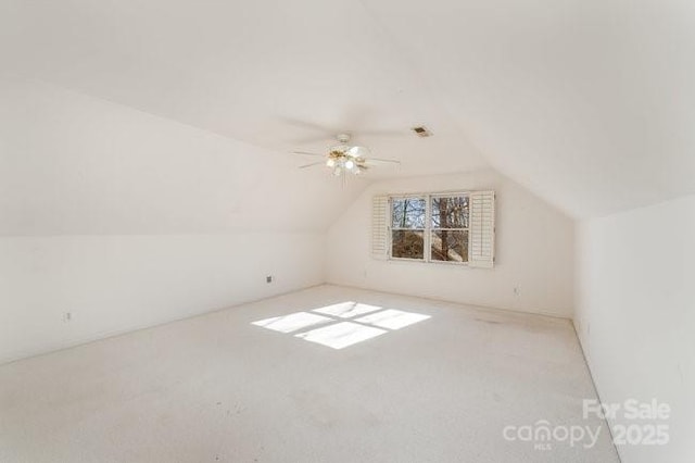 additional living space featuring light carpet, ceiling fan, and lofted ceiling