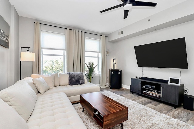 living room featuring wood-type flooring and ceiling fan