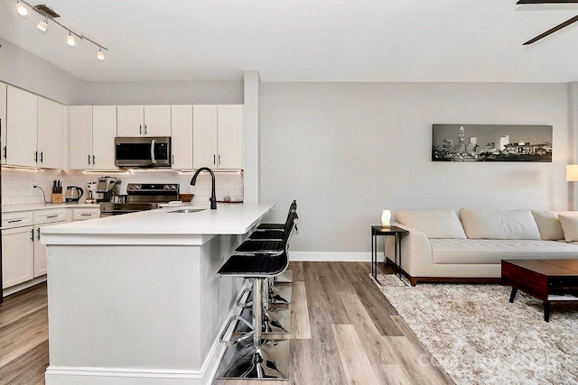 kitchen featuring appliances with stainless steel finishes, sink, decorative backsplash, and white cabinets