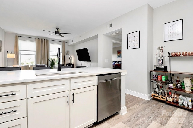 kitchen with sink, white cabinets, stainless steel dishwasher, ceiling fan, and light hardwood / wood-style floors