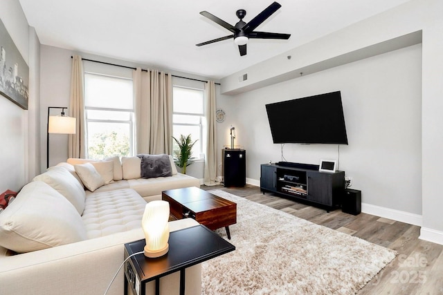 living room featuring light hardwood / wood-style flooring and ceiling fan