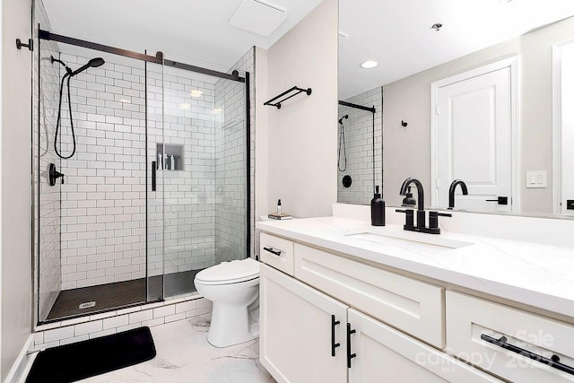 bathroom featuring walk in shower, vanity, and toilet