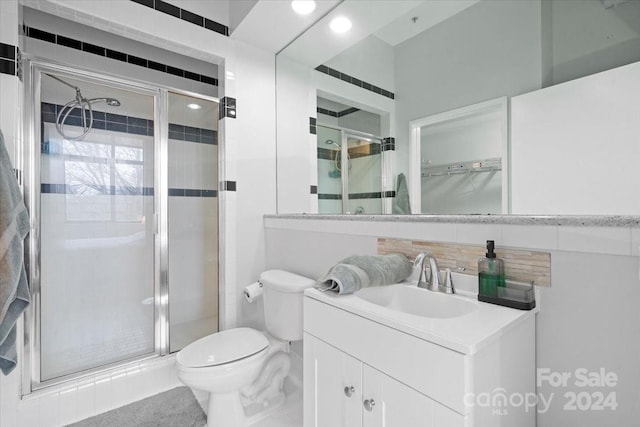 bathroom featuring vanity, toilet, and an enclosed shower