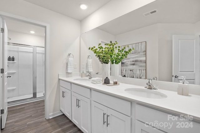 bathroom with a shower with door, vanity, and wood-type flooring