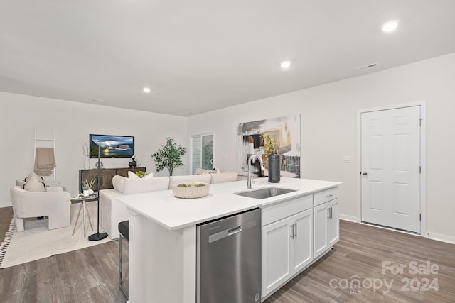 kitchen with stainless steel dishwasher, sink, wood-type flooring, a center island with sink, and white cabinets