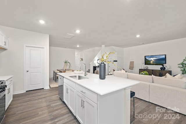 kitchen with sink, hardwood / wood-style floors, an island with sink, a kitchen bar, and white cabinets