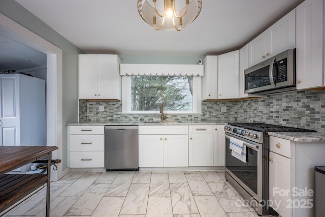 kitchen featuring decorative backsplash, sink, white cabinets, and appliances with stainless steel finishes