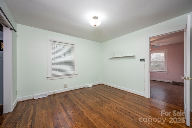 empty room featuring dark hardwood / wood-style flooring and ceiling fan