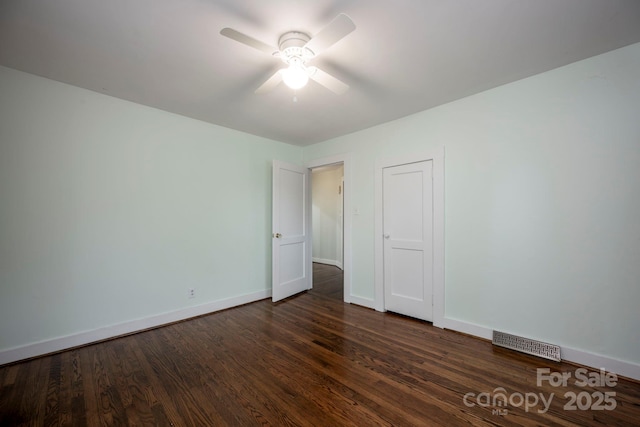 spare room with dark hardwood / wood-style floors and ceiling fan