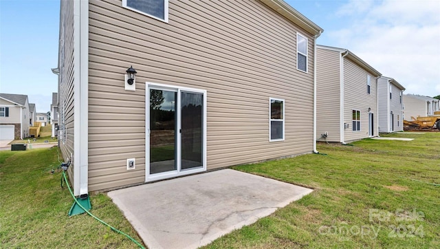 back of property with a yard and a patio