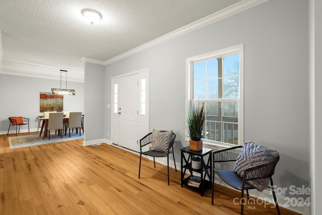 entrance foyer with crown molding, hardwood / wood-style floors, and a textured ceiling