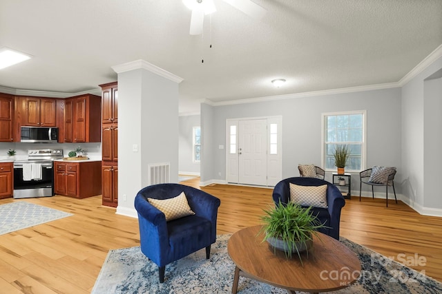 living room featuring a healthy amount of sunlight, light hardwood / wood-style flooring, and crown molding