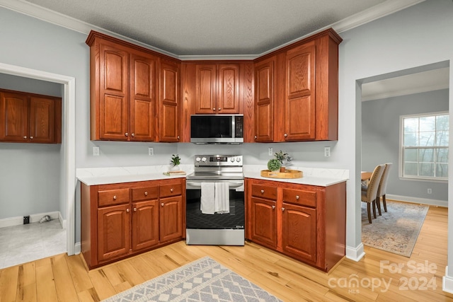 kitchen with a textured ceiling, crown molding, stainless steel appliances, and light hardwood / wood-style flooring