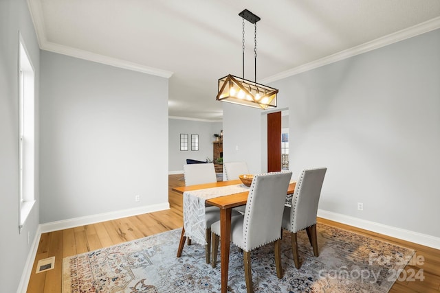 dining room with hardwood / wood-style floors and crown molding