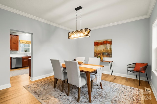 dining space featuring sink, light hardwood / wood-style floors, and ornamental molding