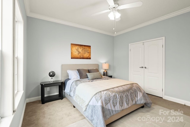 bedroom with light carpet, ceiling fan, ornamental molding, multiple windows, and a closet