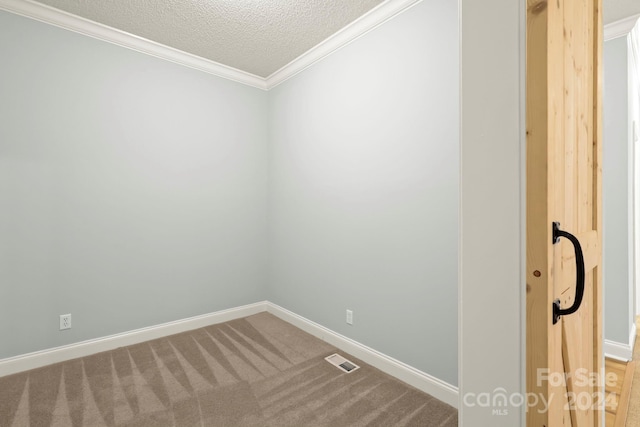 spare room with carpet flooring, a textured ceiling, and ornamental molding