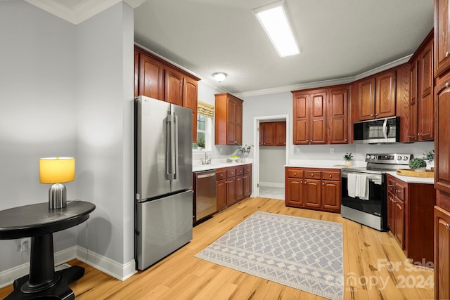 kitchen featuring light wood-type flooring, crown molding, and appliances with stainless steel finishes